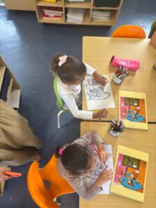 deux élèves de maternelles vus du dessus font du coloriage
