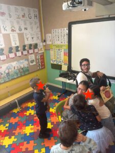 Deux élèves de maternelle enlace une collégienne. A côté d'elle se trouve un collégien en fauteuil roulant et deux autres élèves de maternelle. 