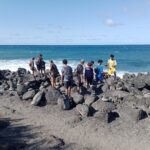 groupe d'élèves au bord de mer (etang salé) entourés de cairn