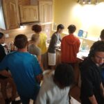 Groupe d'élèves qui est dans une cuisine et prépare à manger